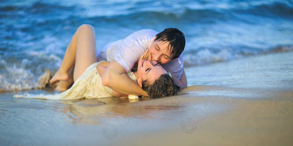 Um casal dando uns pega na praia
