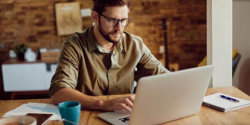 Um homem pesquisando com um computador